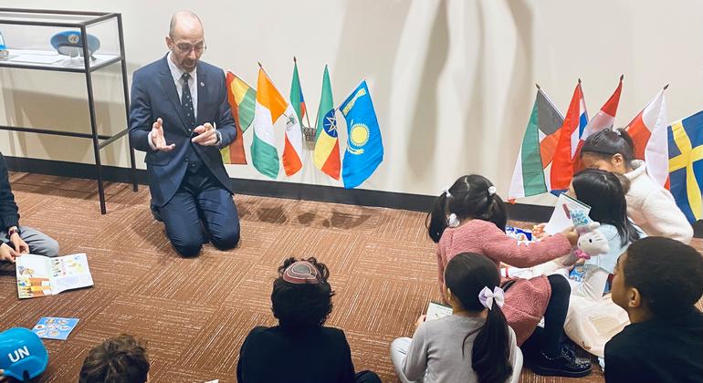 راهنمای تور سازمان ملل، جاناتان میشال، سازمان ملل را برای گروهی از کودکان خردسال توضیح می دهد.